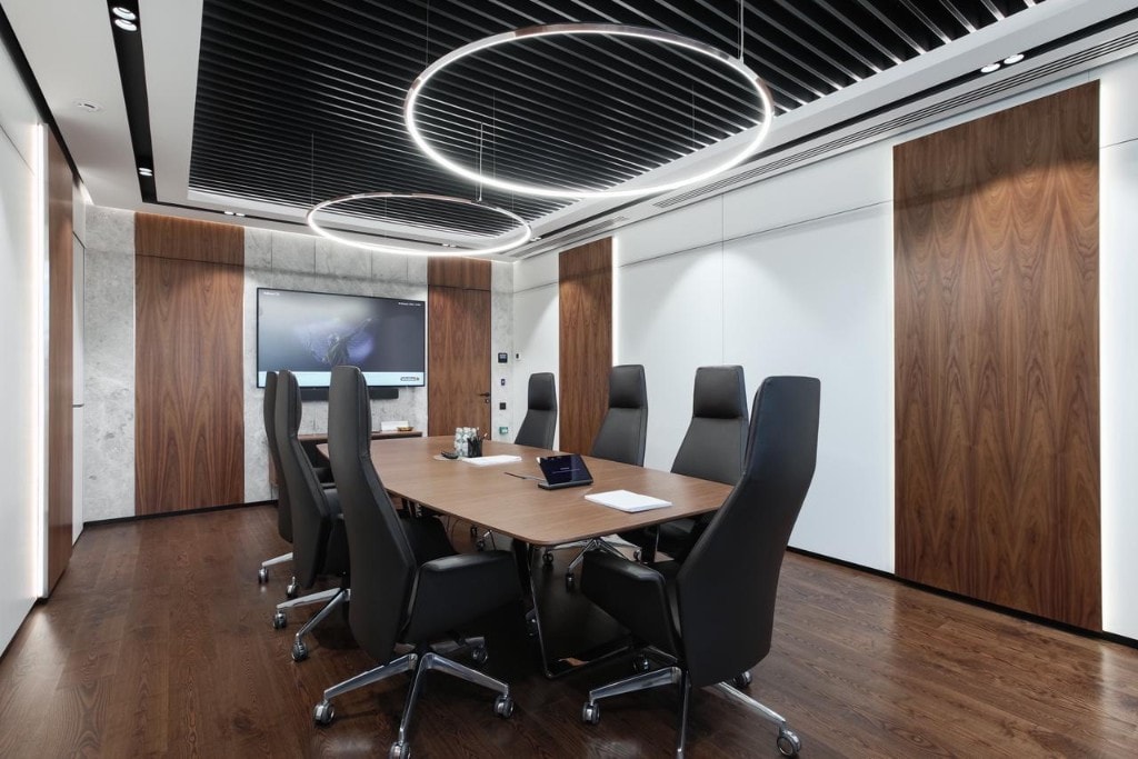 Executive boardroom with ring pendant lights and wood-panel walls
