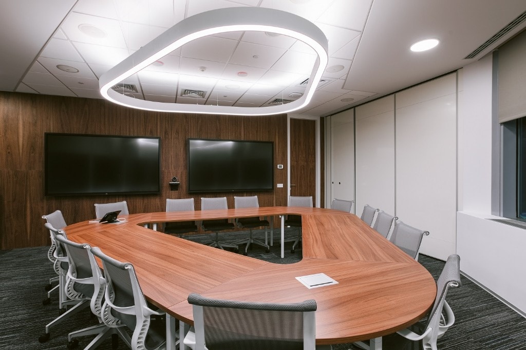 Boardroom with halo pendant light and wood-panel feature wall