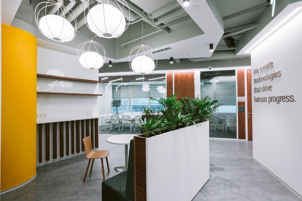 Breakout area with spherical pendant lights and brand feature wall