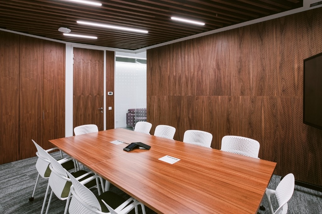 Conference room with perforated wood acoustic panels and slatted ceiling