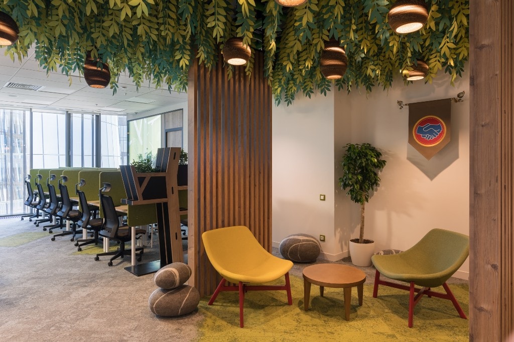 Biophilic lounge with hanging vines and mustard accent seating