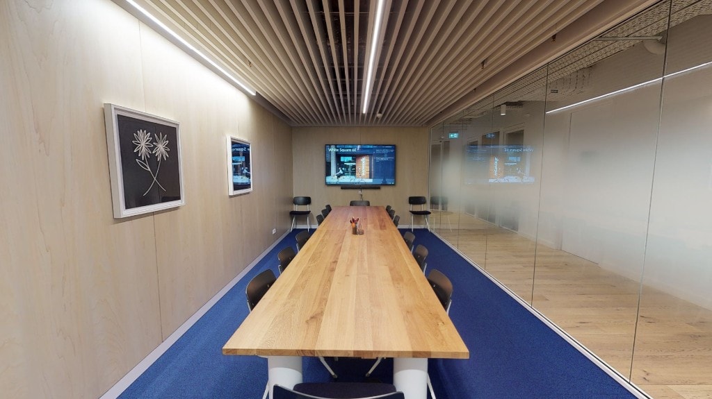 Conference room with wood panel walls and blue carpet flooring