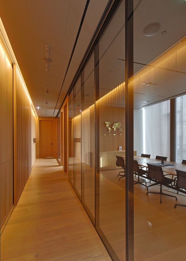 Wood-slatted corridor with glass-partitioned conference room