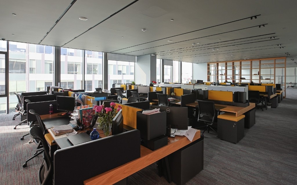 Open-plan office with yellow privacy screens and workstations