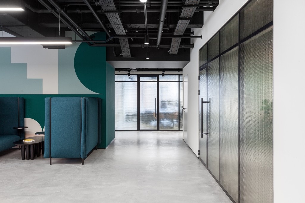 Teal acoustic breakout pods with geometric wall art