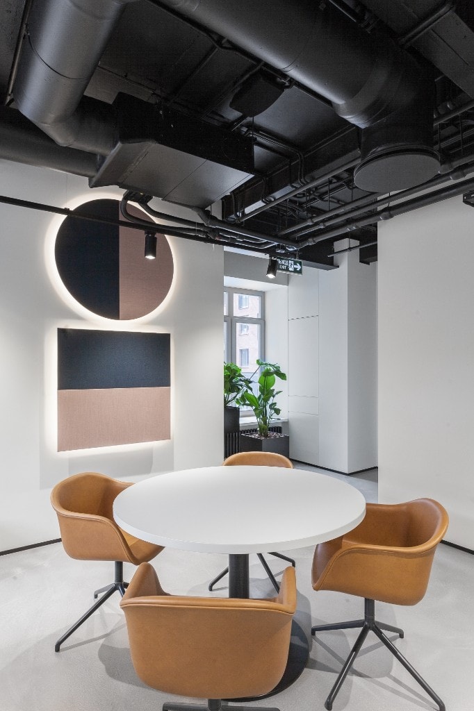 Round-table meeting nook with backlit wall panels
